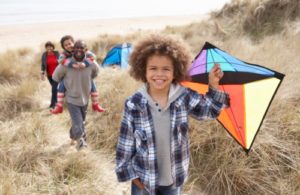 Family Having Fun With Kite In Sand Dunes